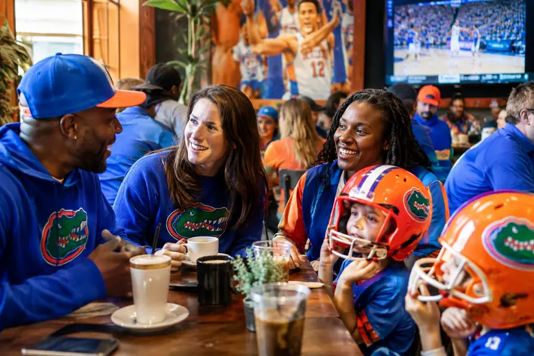 Fans enter a basketball arena concourse before a Florida home game