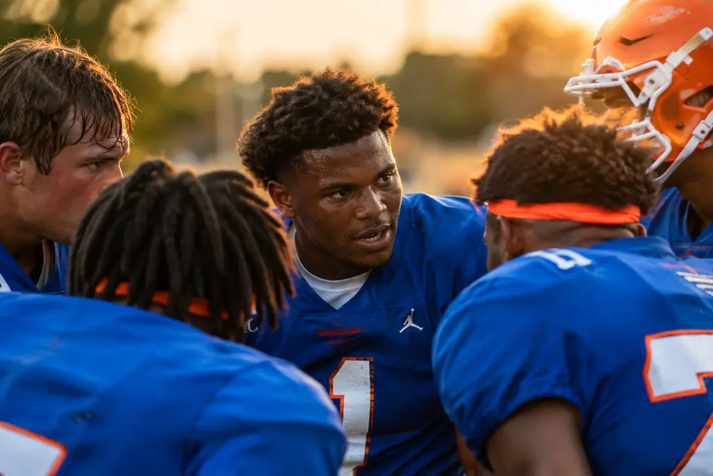 Gators Returning Players gather on a football practice field before a fall workout