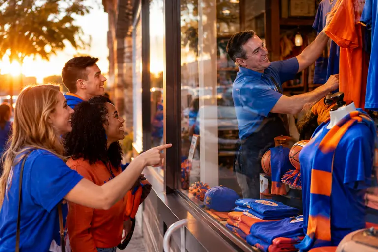 Local fans walk past restaurants near campus before a basketball game